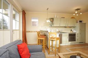 ein Wohnzimmer mit Couch und Küche in der Unterkunft Strandvilla Böck FeWo 10 strandnah, Balkon, Meerblick in Glowe + 13 Fotos