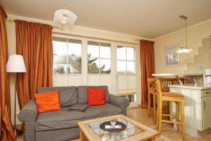 ein Wohnzimmer mit einer Couch und einem Tisch in der Unterkunft Strandvilla Böck FeWo 10 strandnah, Balkon, Meerblick in Glowe