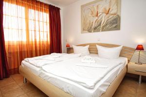 ein großes weißes Bett in einem Zimmer mit Fenster in der Unterkunft Strandvilla Böck FeWo 10 strandnah, Balkon, Meerblick in Glowe