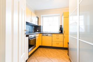 eine Küche mit gelben Schränken und einem Fenster in der Unterkunft Omas Haus in Staberdorf