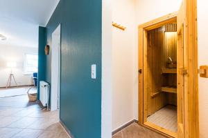 einen Flur mit blauer Wand und Holztür in der Unterkunft Omas Haus in Staberdorf