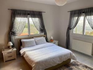 a bedroom with a large bed with two windows at Letymvou Terrace in Letimbou +62 photos