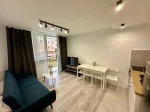 奥斯威辛Apartament Powstańców 17的客厅里有一张沙发和一张桌子。