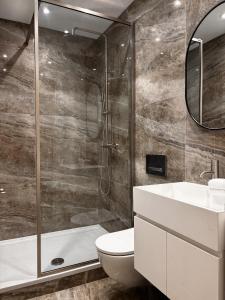 a bathroom with a shower and a toilet and a sink at Central Todmorden 2 Bedroom Apartment in Todmorden