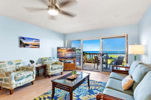 een woonkamer met een bank en een tafel bij Oceanfront & Sunsets! ks a5- Sullivan in Kahana