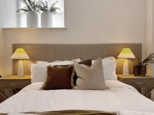 a bedroom with a white bed with pillows and two lamps at Central Todmorden 2 Bedroom Apartment in Todmorden