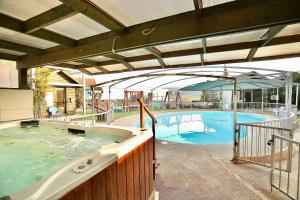 a large swimming pool with an umbrella next to it at אגם ריזורט בטבע in Kallanit