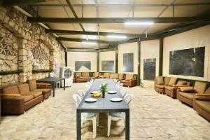 a large room with a table and chairs and couches at אגם ריזורט בטבע in Kallanit