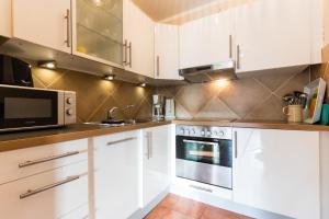 a kitchen with white cabinets and a microwave at Pferdewiese in Staberdorf