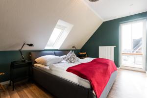a bedroom with a bed with a red blanket on it at Pferdewiese in Staberdorf