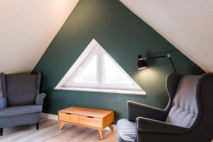 a living room with two chairs and a window at Pferdewiese in Staberdorf +38 photos