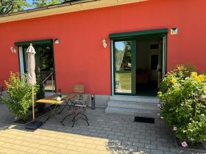 a red building with a table and chairs in front of it at Bed & Breakfast am Waldgürtel in Forst +37 photos