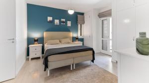 a bedroom with a bed with a blue accent wall at Beautiful Junior Villa GZ01, next to Communal Pool, Aphrodite Hills in Kouklia +41 photos