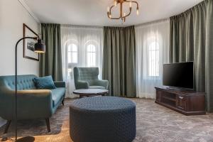 a living room with a couch and a tv at Home Hotel Victoria in Jönköping