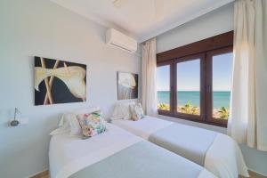 twee bedden in een slaapkamer met uitzicht op de oceaan bij Playa Bajondillo Terrace - Free Parking in Torremolinos