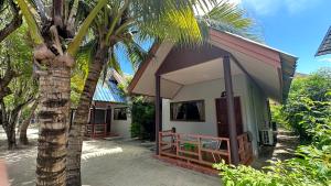 una piccola casa con una palma accanto di Andaman Resort a Phi Phi Don