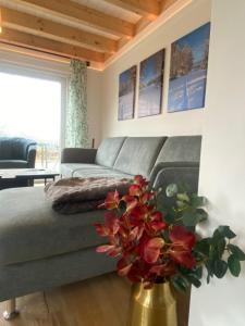 モンシャウにあるSchwedenhaus Fridhem Hügelglück mit Weitblickのソファと花瓶のあるリビングルーム
