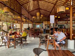 a group of people sitting at tables in a restaurant at Andaman Beach Resort by Zodiac in Ko Lipe