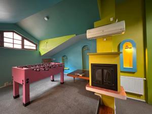 a room with a play room with a table and a fireplace at 25 Hours Hostel in Vilnius