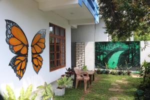 a butterfly painted on the side of a house at Costels Mirissa in Mirissa