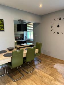 ein Esszimmer mit einem Tisch, Stühlen und einer Uhr in der Unterkunft Apartmány Klicperka in Liberec