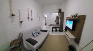 a living room with a couch and a tv at Apart511 in Santos