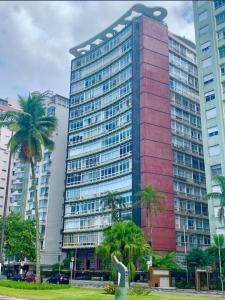a tall building with palm trees in front of it at Apart511 in Santos