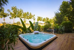 a hot tub sitting on a wooden deck at Alaya Stays Dacha 3 BHK Villa with Jacuzzi & Outdoor Bar in Palwal