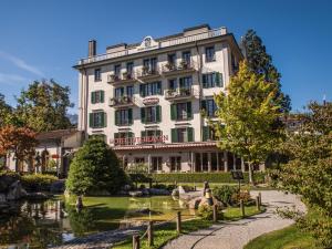 a hotel with a pond in front of a building at Hotel Interlaken in Interlaken +61 photos