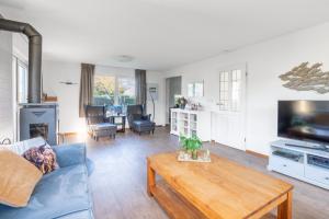 a living room with a blue couch and a coffee table at Villapark Kamperfoelie 75 in De Koog