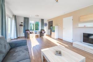 una sala de estar con un sofá y una mesa en Villapark Kamperfoelie 97, en De Koog