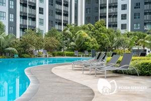 万津Maya Bay Residences at Gamuda Cove, Dengkil by Plush的游泳池旁的一排躺椅