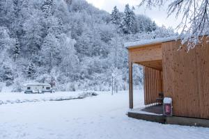 a small wooden cabin with a snow covered yard at Apartment am Camping Dornbirn - 212 Salzbödenkopf in Dornbirn