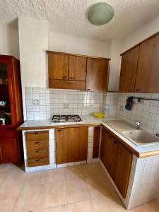 an empty kitchen with wooden cabinets and a sink at TIZIANA HOME II - Appartamento ad Ovindoli - Residence Al Park in Ovindoli