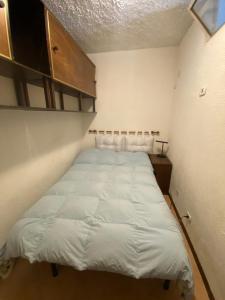 a small bedroom with a bed in the corner at TIZIANA HOME II - Appartamento ad Ovindoli - Residence Al Park in Ovindoli