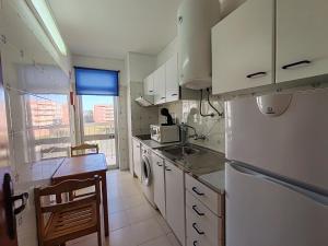 a kitchen with white cabinets and a sink and a refrigerator at 4D Torre Rafael - Casas & Papéis in Armação de Pêra