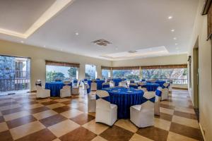 a banquet hall with blue tables and white chairs at Sterling Corbett in Marchula