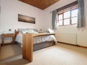 西卢港Owl Cottage的带床和书桌的卧室