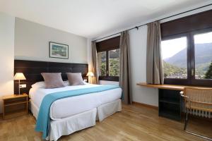 una habitación de hotel con una cama y una ventana grande en Hotel Blu Aran, en Vielha