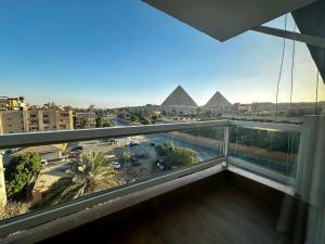 a view of the pyramids from the balcony of a building at DouDou Pyramids View Hotel in Cairo