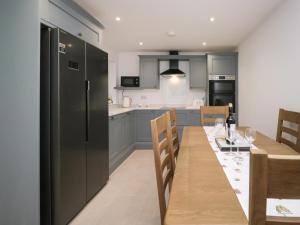 a kitchen and dining room with a table and a refrigerator at Apple Tree Barn in Dalton in Furness