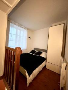 a small bedroom with a bed and a window at Joli appartement avec cachet dans le Vieux Lille in Lille