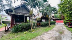 una casa con delle palme davanti di New Klong Khong Garden a Ko Lanta