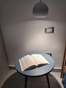 an open book on a blue table under a light at CasaManù in Cesano Maderno