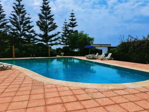 una piscina con acqua blu in un cortile di Villa by the Oualidia Lagoon a Oualidia