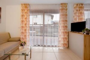 a living room with a couch and a large window at Night and day 3 in Predazzo