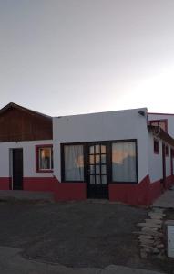 un edificio rojo y blanco con un edificio rojo y blanco en Hospedaje el buen descanso, en Gobernador Gregores