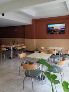 a restaurant with tables and chairs and a tv on the wall at Etoile in Mar del Plata