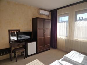 una camera d'albergo con TV e mobile con TV di Хотел Релакс a Velingrad