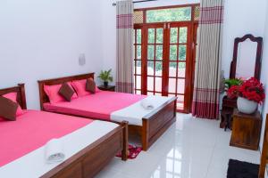a bedroom with two beds and a window at Flower Top Ella in Ella